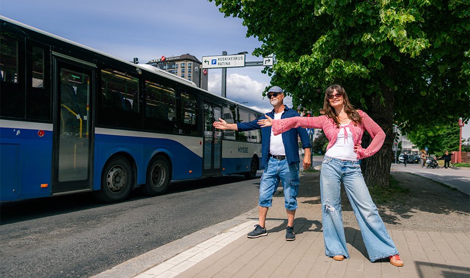 Mies ja nainen heilauttavat kättään Nyssen bussille kadun varrella, Tampereen keskustassa. 