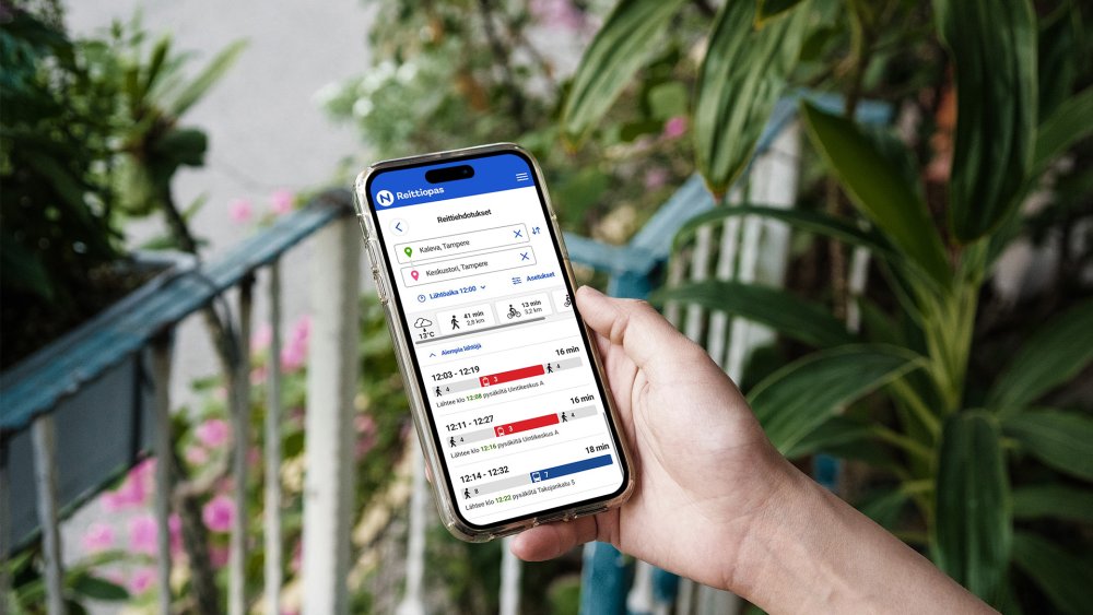 A person is holding a phone in their hand, with Nysse's journey planner displayed in the browser.