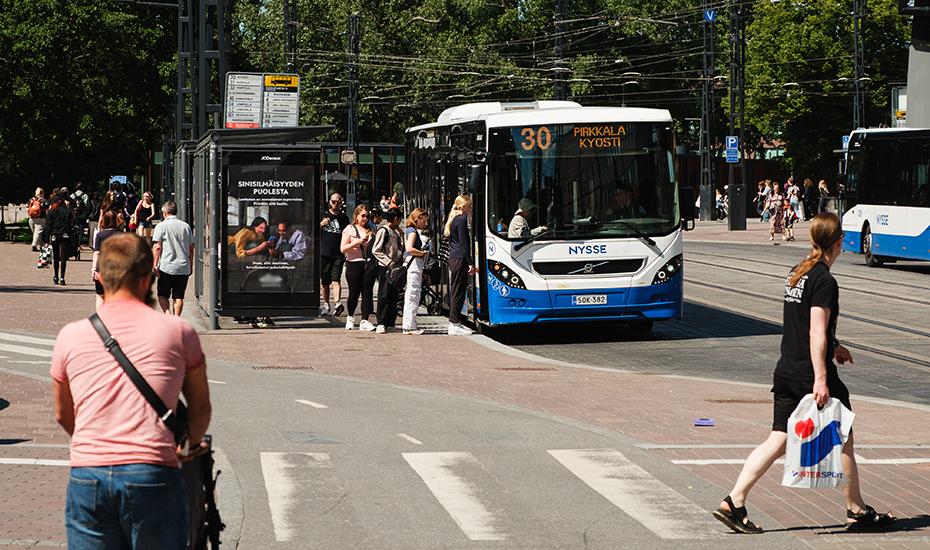 Ihmisiä nousemassa bussiin Koskipuistossa.