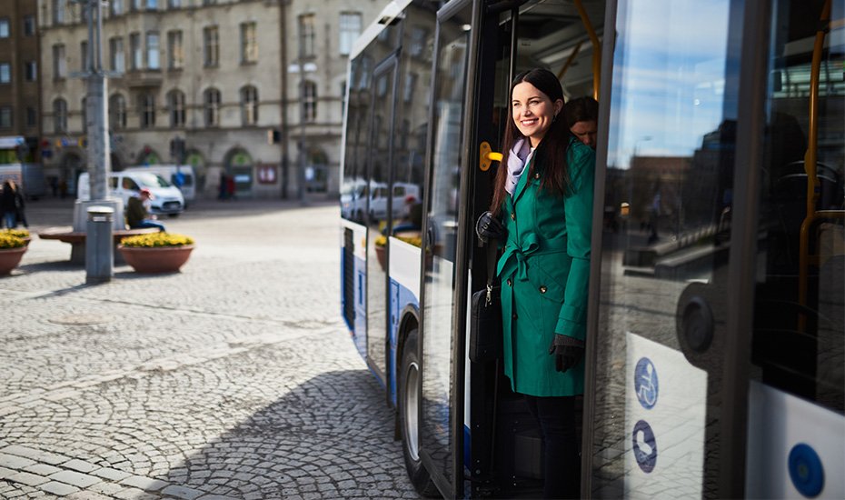 Nainen astuu ulos bussista. 