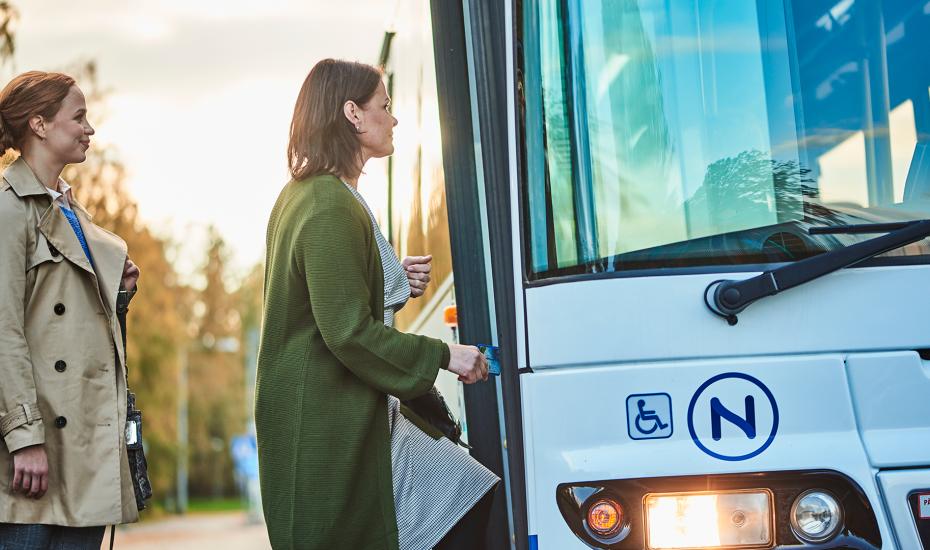 Kaksi naista nousee bussin kyytiin. 