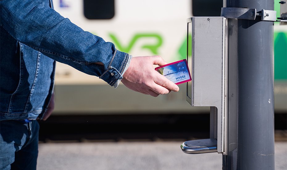 Illustration: A passenger checking in at the train station platform using travel card.