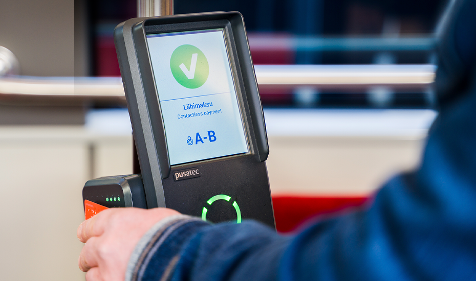 A traveller is setting his credit card on the reader of the ticket device.