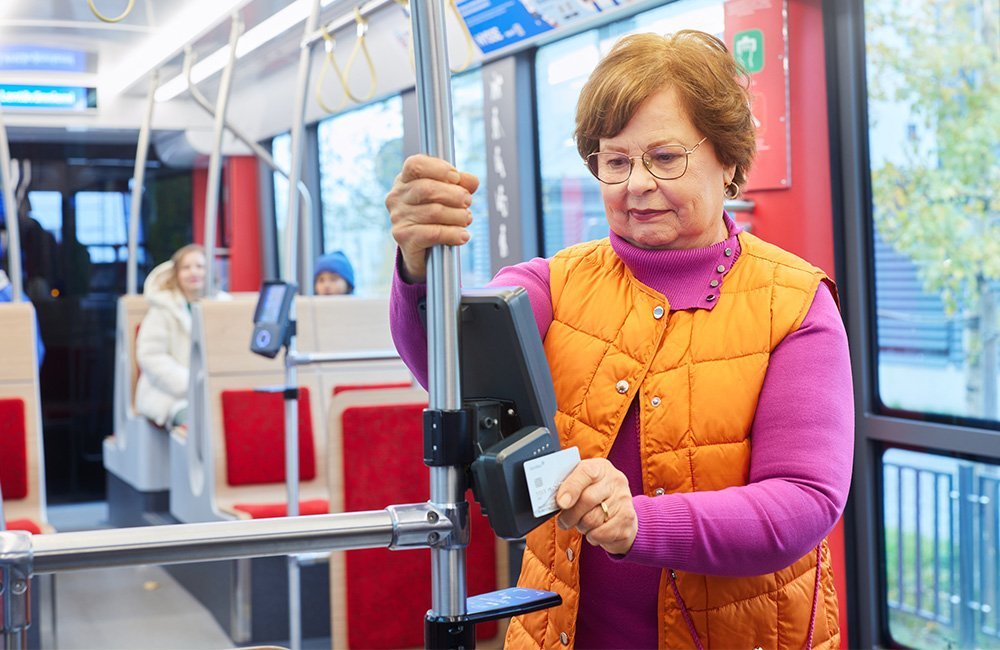 Matkustaja käyttää pankkikorttiaan lippulaitteen vasemmassa reunassa sijaitsevassa lukijassa.