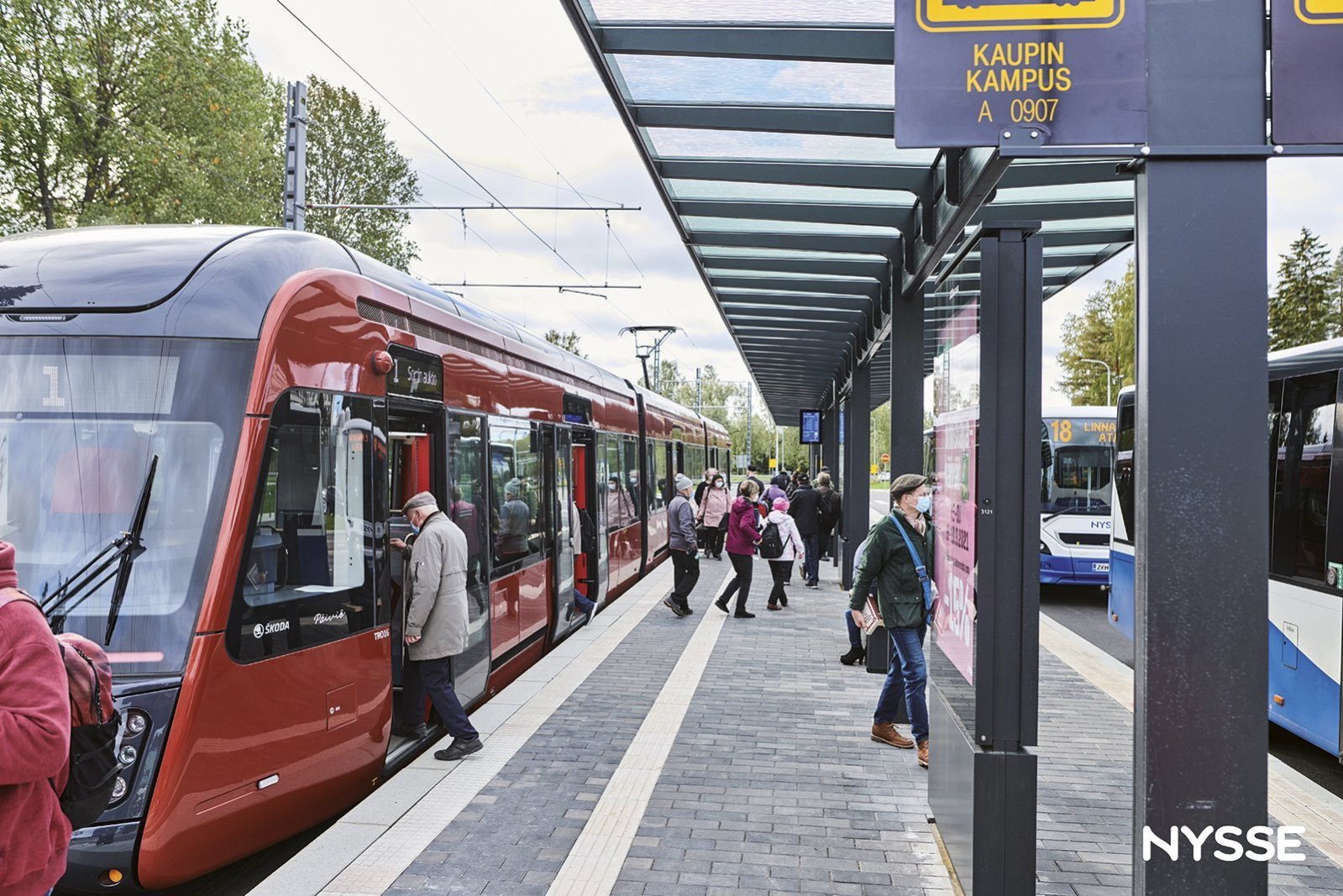 Ratikka, bussi ja matkustajia Kaupin kampuksella